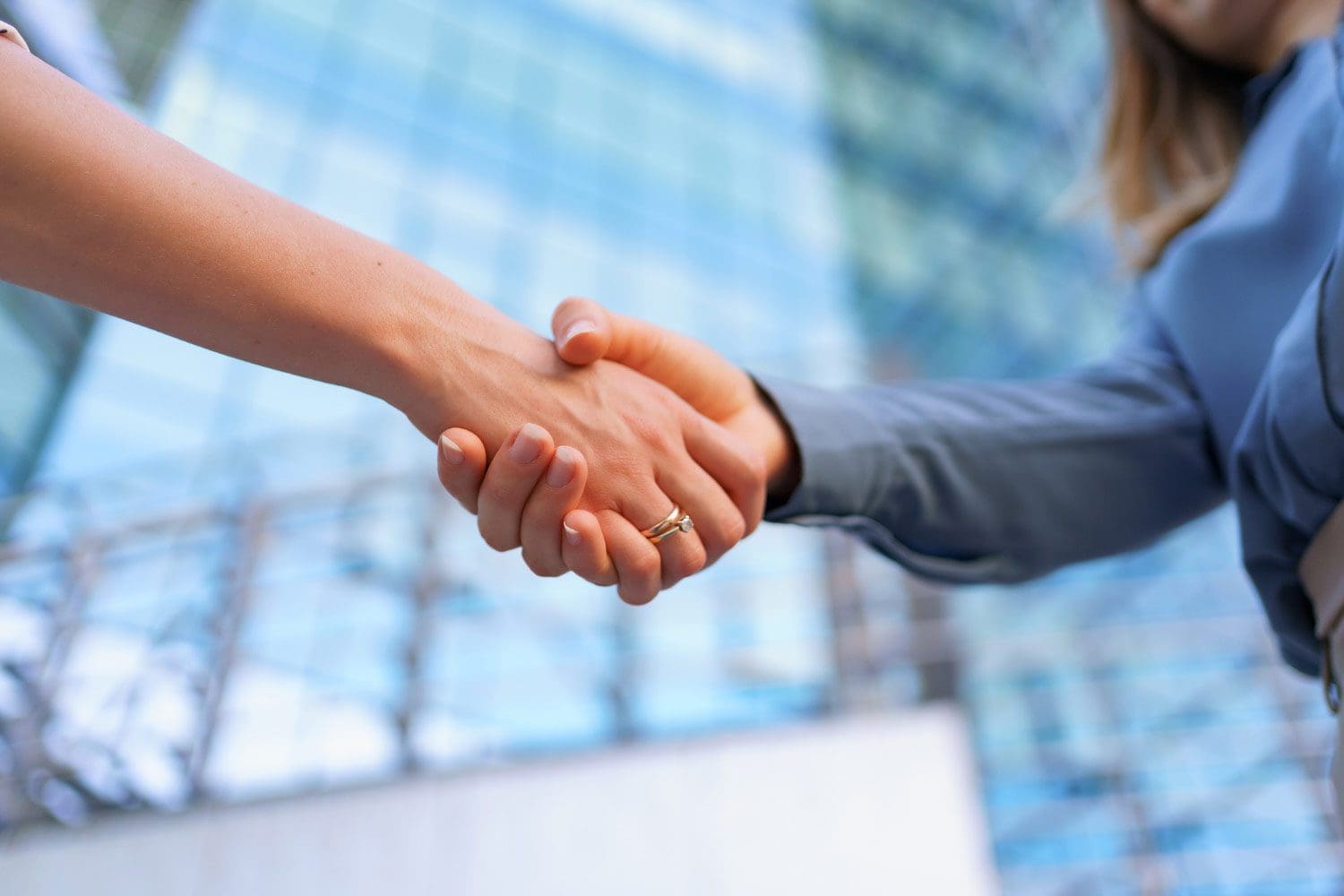 A woman shaking hands outside a business building in the USA